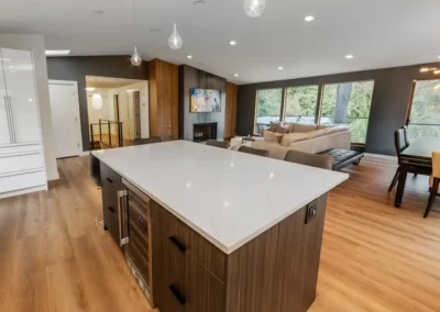 Kitchen island with stone top, custom oak hardwood cabinets, and beverage refrigerator.