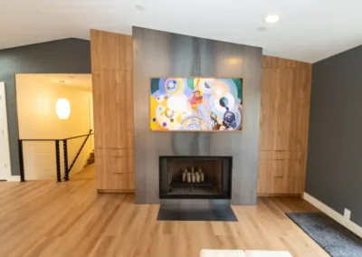 Custom steel fireplace and hearth flanked by custom hardwood oak cabinets.