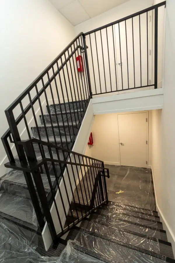 Upgraded stairway with custom iron railings, new stair treads, lighting, and paint.