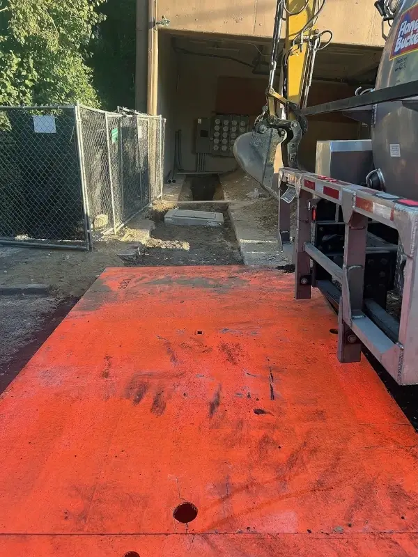 Backfilled trench with underground power conduit at garage entry.