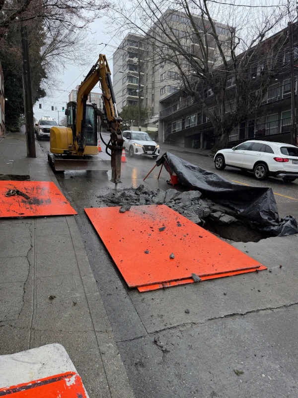 Breaking concrete before digging sewer line trench.