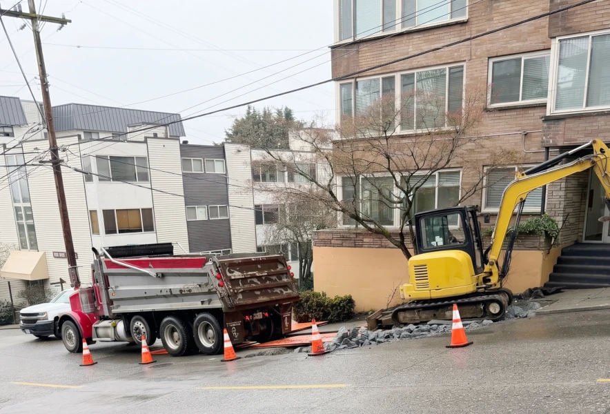 Breaking and removing concrete before sewer line trenching. 